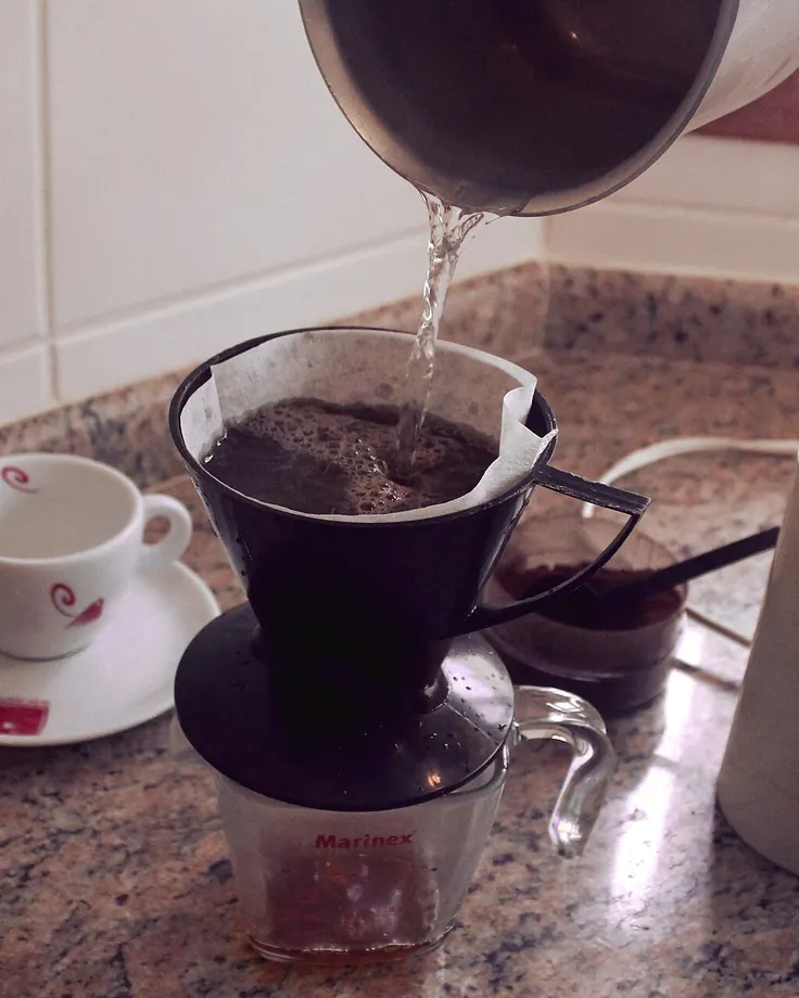 قهوه قطره‌ای خانگی با صافی کاغذی و کتری روی پیشخوان سنگی؛ روشی دوست‌دار کلسترول