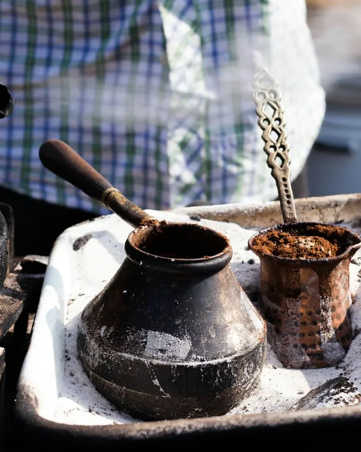 دو جذوه قهوه ترک داخل شن داغ برای دم‌آوری با کف پرپشت