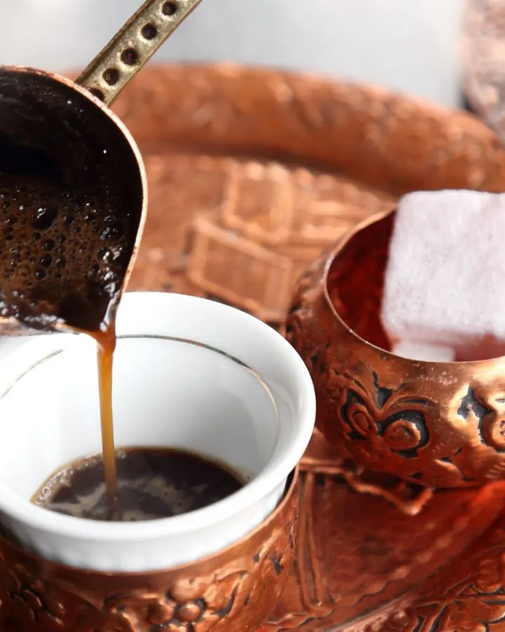 جذوه مسی و فنجان قهوه ترک روی سینی؛ آماده‌سازی فنجان برای فال