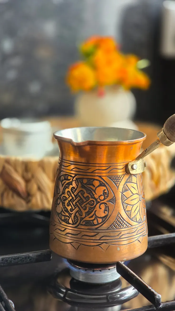 جذوه مسی حکاکیشده روی شعله گاز برای دمکردن قهوه قود خانگی