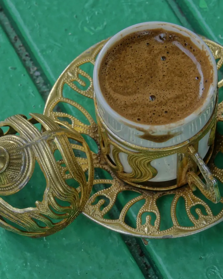 فنجان قهوه ترک با کف غلیظ در ظرف فلزی سنتی برای مقایسه با قهوه قود