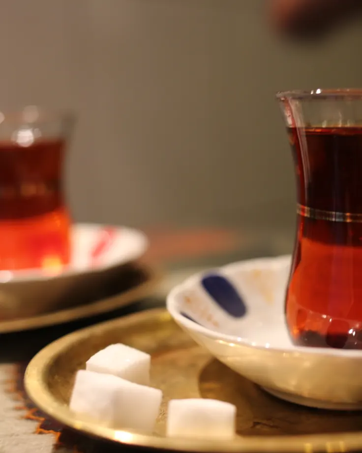 دو استکان چای کمرباریک با قند روی سینی برنجی؛ رقیب قدیمی قهوه در تاریخچه قهوه در ایران