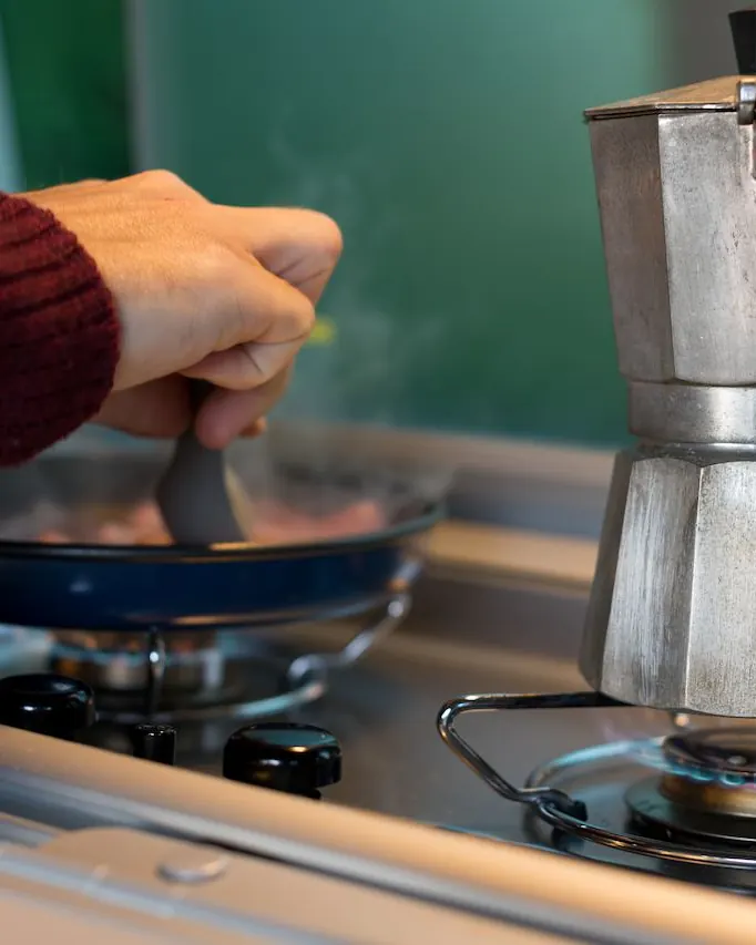 موکاپات آلومینیومی روی شعله کوچک اجاق با قهوه در حال جوشیدن