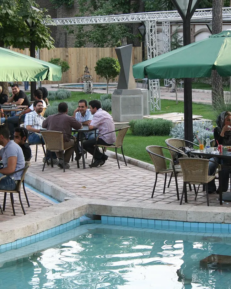 حیاط کافه باغ با چتر برای دورهمی در تهران